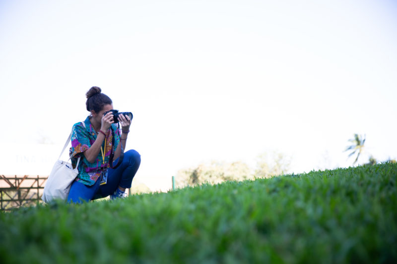 Annabelle Correa holding camera crouch and looking outside of frame