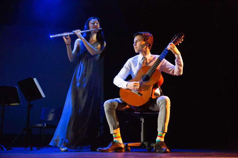 Irene Kim playing the flute next to seated classical guitarist Ansel Bobrow