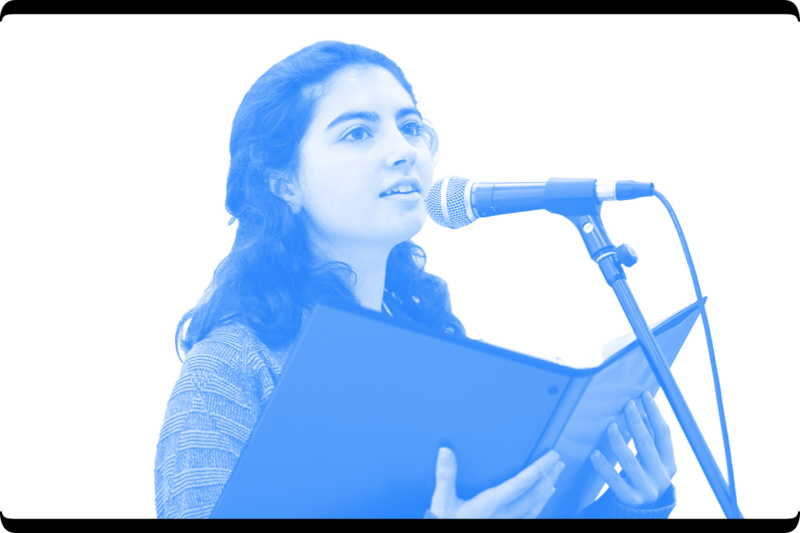 Young woman reading into a microphone