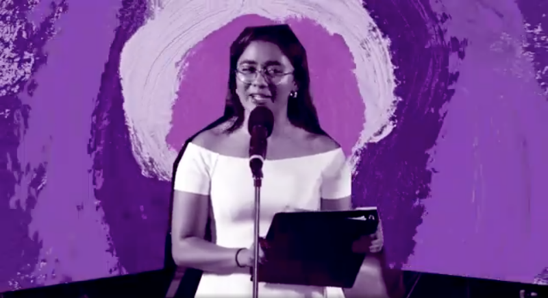 Writer reading her work in front of a purple background